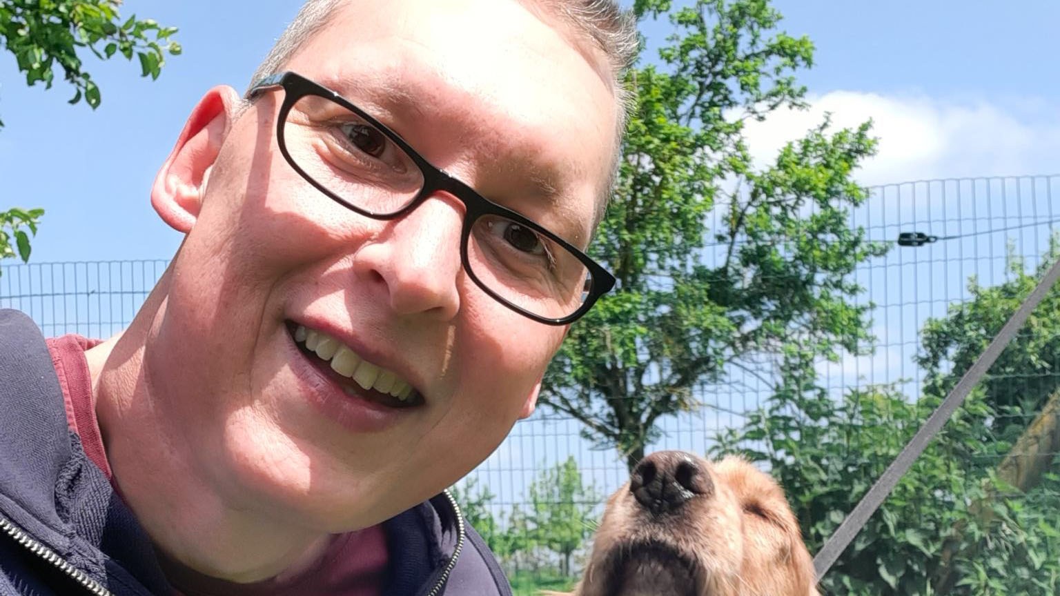 Simon neben seinem Hund mit BVB-Halstuch.